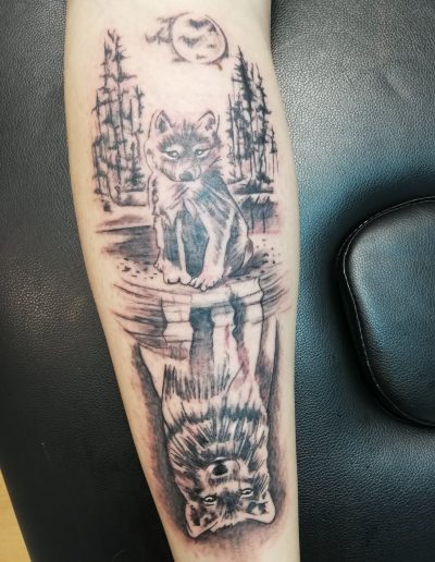 tatouage avec loup reflet dans l'eau en noir et blanc so-tattoo les essarts 85
